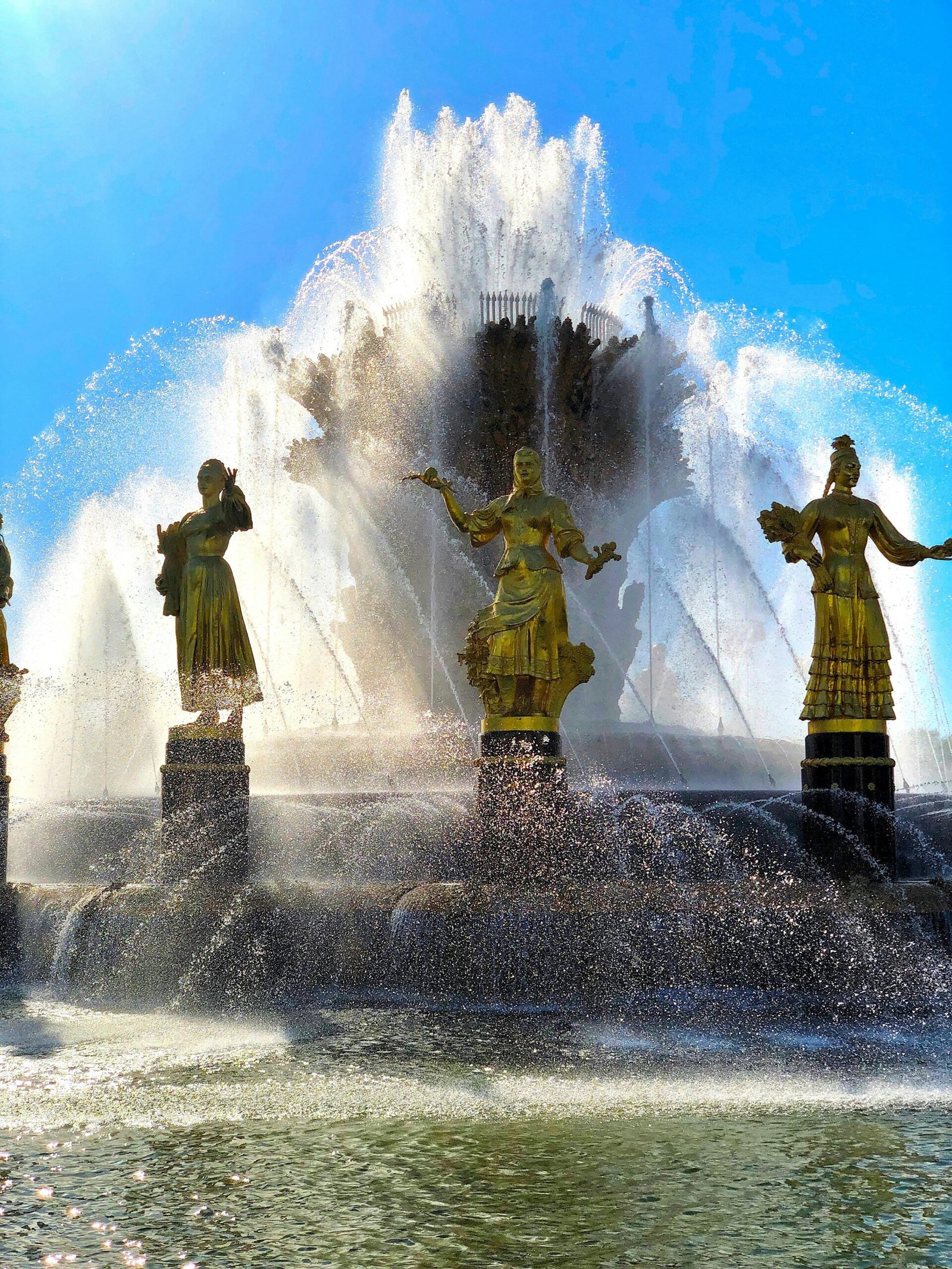 a group of statues sitting on top of a fountain